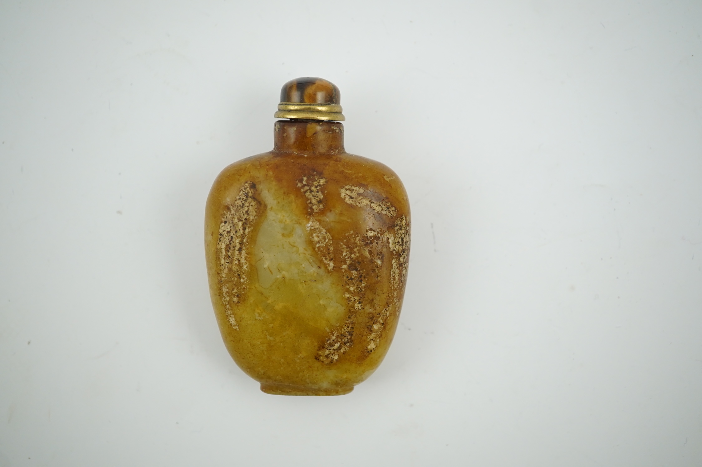 A Chinese soapstone snuff bottle with tiger's eye stopper, 8cm high. Condition - fair